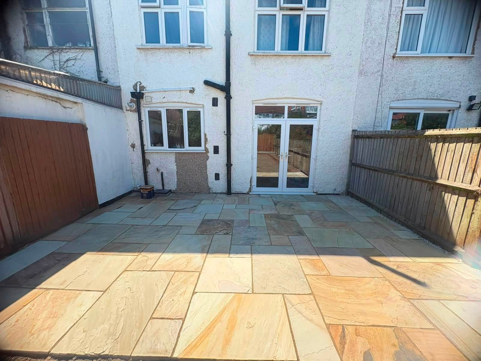 Riven Indian sandstone patio laid across a rear garden